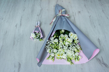 Large and small bouquets of flowers on a white wooden background. A bouquet for mother and daughter. Mother's Day. International Women's Day. The concept of the holiday