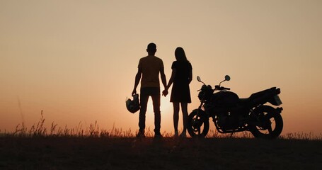 Romantic pair of bikers meets sunset in nature