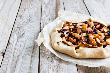 Mixed Apple and Berry Galette on wooden background.