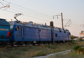 The locomotive moves on a track on a clear summer day