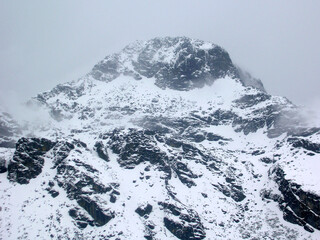 The dark rocky terrain covered with snow after the fresh snowfall at Nathula Pass, Indo-China border situated at 14,500 ft altitude in Sikkim. Temperature is Deeping up to - 10 celsius with cold.