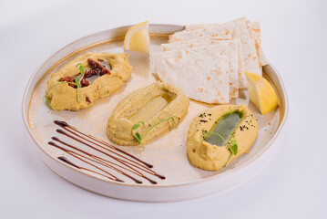 Three types of hummus with different flavors and cornbread
