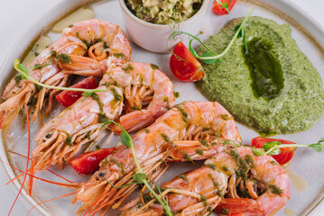 Dish of king prawns and spinach sauce on a white background