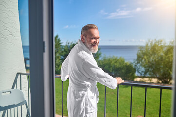 Happy holidaymaker posing for the camera in his hotel room