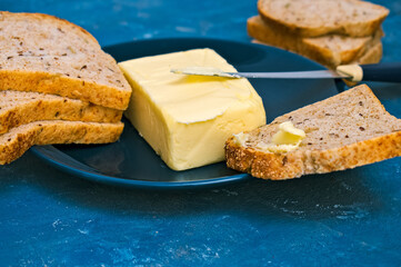 butter and toast bread on a blue plate. close. macro.