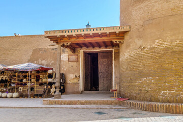 Fototapeta na wymiar Entrance to Juma Mosque, one of most ancient mosques in Khiva, Uzbekistan. On the left is lower part of the minaret. Building founded in 10th century