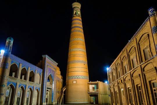 Night view of the ancient buildings of Khiva. From left to right: Islam Khoja madrasah and minaret, Russian school. All buildings were built at the beginning of the 20th century
