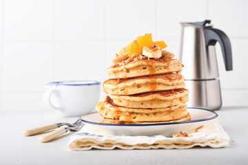Pancakes. Homemade fluffy pancake with banana, walnut and caramel for breakfast on light concrete background. Delicious pancakes for traditional American breakfast. Selective focus. Mock up.