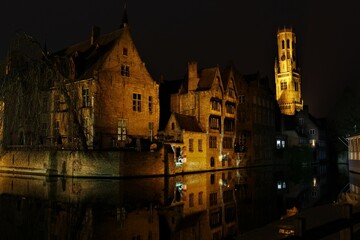 Obraz premium Bruges canals in winter at night with view of the Belfry (Belgium). West Flanders buildings and architecture.