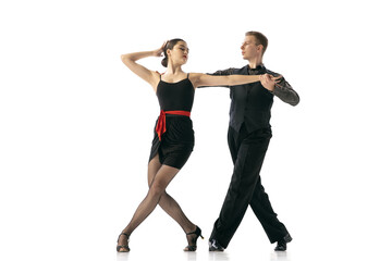 Grace and beautiful dancers, young couple dancing Argentine tango isolated on white studio background. Artists in black stage costumes