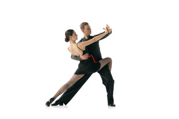 Flexible young couple dancing Argentine tango isolated on white studio background. Artists in black stage costumes