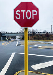 Stop sign by dangerous intersection with train tressel in background - obrazy, fototapety, plakaty