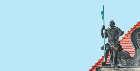 Fototapeta premium Banner with a very old statute heavy armed gatekeeper, a medieval warrior with spear in historical downtown of Dresden at blue sky and copy space, Germany.