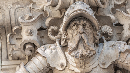Ancient big statute of scary, fearful and heavy armed gatekeeper, medieval warrior with weapon in historical downtown of Dresden, Germany, details, closeup. Authentic European old architecture.