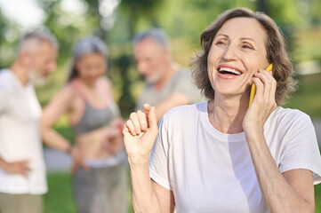 Fototapeta premium Short-haired woman in a white tshirt with a smartphone