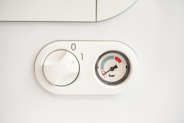 Indicators and key for the regulation of a gas boiler located on a wall.