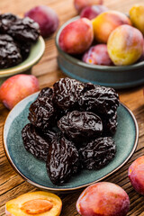 Fresh  prune and dried  prune on wooden board background