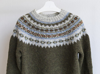 Brown and grey Icelandic wool knitted lopapeysa sweater in traditional nordic pattern, close up...