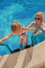 Fototapeta na wymiar Mother and daughter having fun in the swimming pool