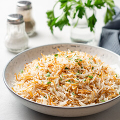 Rice with vermicelli in plate on concrete background. Traditional arabic dish.