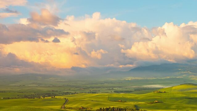 Time lapse of the morning fog and clouds moving over the rolling green hills of Tuscany Italy.