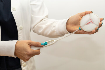 Doctor holds in her hands a copper coil device for birth control (DUI). Birth control and...