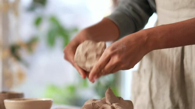 Female hands sculpt a bowl of clay at home