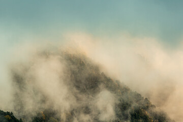 朝日に煙る紅葉の山