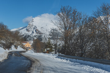 A picturesque landscape view of the road in the snowcapped French Alps mountains on a sunny winter day (the Devoluy valley)