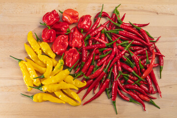 Bunch of assorted hot chili peppers on a wooden table