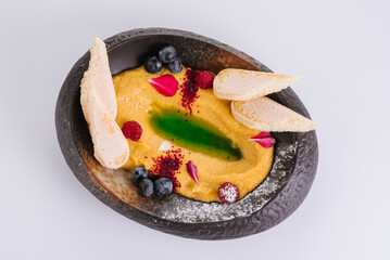 Dietary dessert of pumpkin puree with raspberries, blueberries and croutons