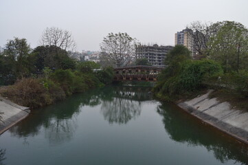 Fototapeta na wymiar canal in the park flowing under a bridge