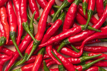 Fresh red hot thai chili peppers on wooden surface