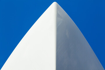 The bow of a white yacht against a blue sky. View from below.