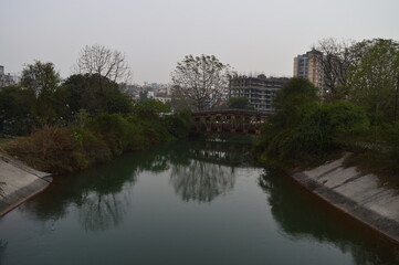 Fototapeta na wymiar water flowing under a bridge in the park