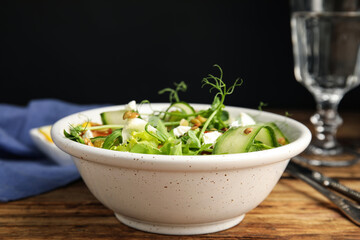 Delicious salad with lentils, vegetables and feta cheese served on wooden table