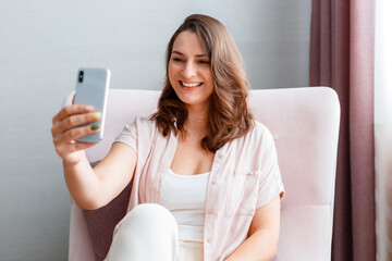 Beautiful tender young smiling caucasian 30s woman taking picture selfie using cell phone. Long...