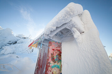  Ribbons sway in the icy wind. Gate of a Buddhist monastery.