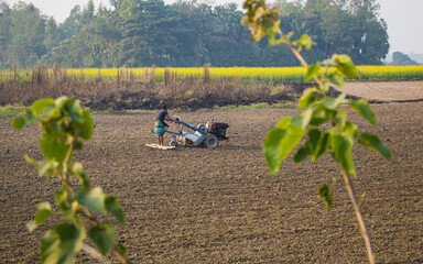 Farmer cultivating field with tractor in winter seasons. I captured this image on January 17, 2022, from Bangladesh, South Asia