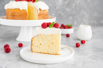 Tres leches cake with whipped cream and fresh raspberries on top of a gray concrete background. Traditional cake from Latin America. Copy space.