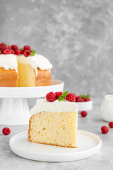 Tres leches cake with whipped cream and fresh raspberries on top of a gray concrete background. Traditional cake from Latin America. Copy space.