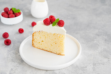 Tres leches cake with whipped cream and fresh raspberries on top of a gray concrete background. Traditional cake from Latin America. Copy space.