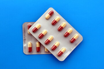  Two plates of medicine in capsules lie on a blue background.