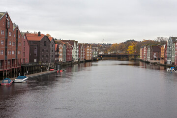 Obraz premium The view from Bakke Bridge: old warehouses line each side of the Nidelva river, Trondheim, Trøndelag, Norway
