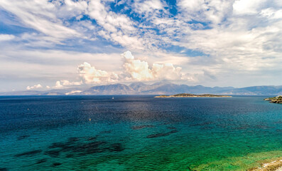 Obraz premium White clouds on blue sky or azure sky background, over mountain ranges and turquoise sea. Seacape