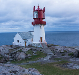 a white - red lighthouse on the Norwegian coast
