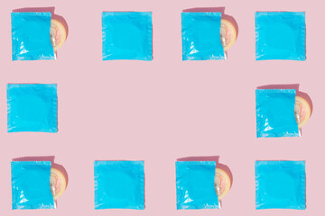 Pattern of blue condoms for safe sex on a pink background. Minimal flat lay concept.