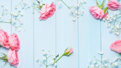 Delicate pink roses and gypsophila on a blue wooden background. Image with selective focus