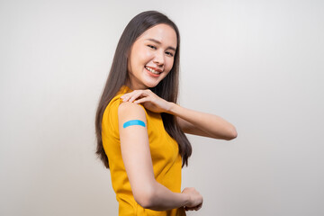 Portrait of pretty, beautiful asian young, teenage attractive after getting, receive anti virus vaccine covid-19. Showing arm on white bandage isolated on white background, copy space.