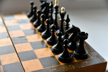 An old chessboard with white and black pieces